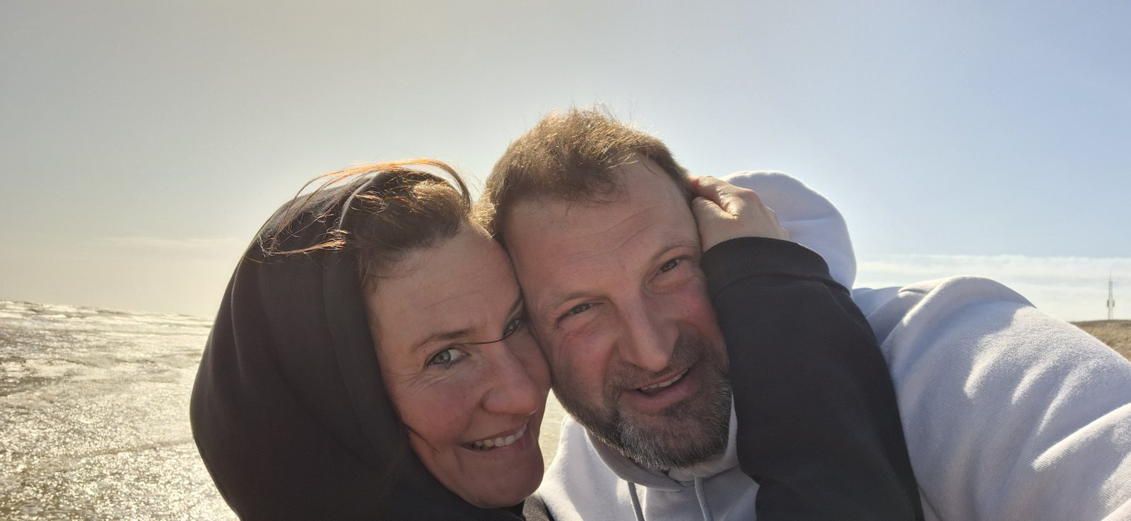 Max und Rieke Weber, die Gastgeber des Weberhofs, Wange an Wange im Sonnenlicht.